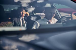 smiling-businessman-with-smartphone-travelling-corporate-transfers