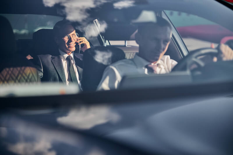 smiling-businessman-with-smartphone-travelling-corporate-transfers
